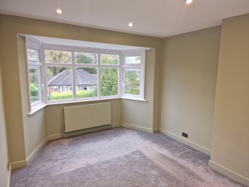 Residential interior painting with soft neutral walls and crisp white trim
